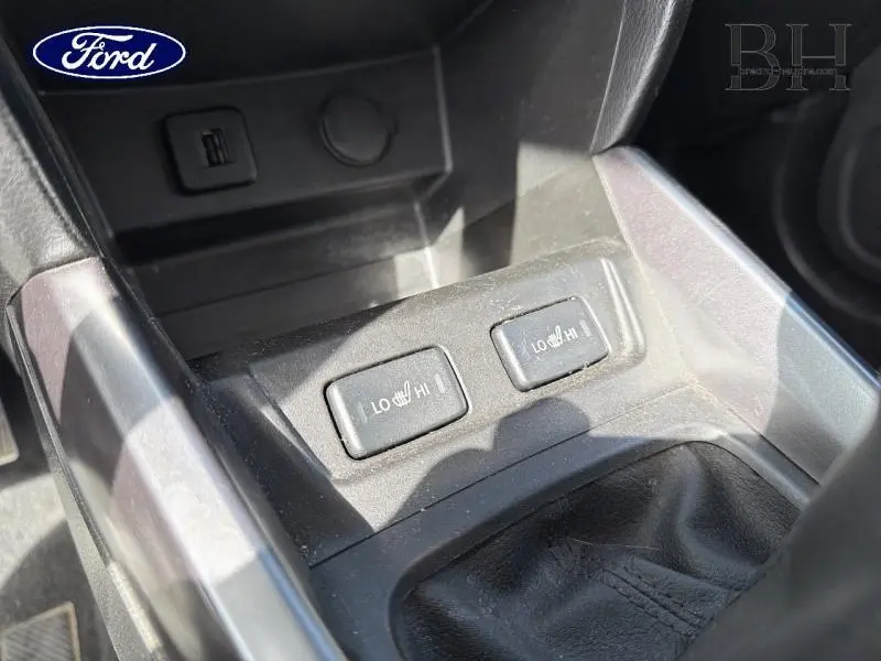 Détail des commandes de sièges chauffants sur la console centrale d’un Suzuki Vitara Cosmic Black Pearl.