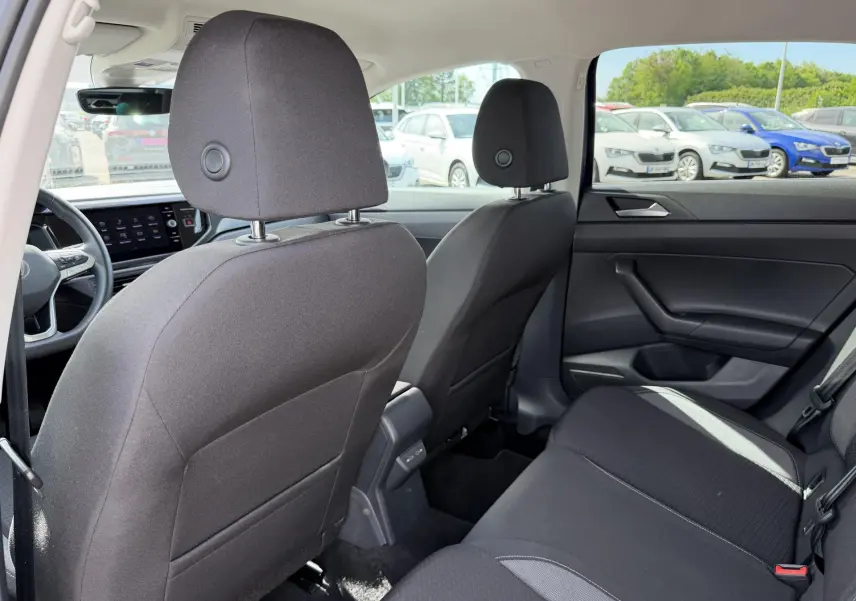 Vue intérieure arrière du Volkswagen Taigo 2025 montrant les sièges noirs et la portière côté droit.