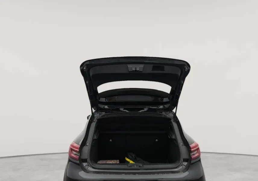 Vue arrière d’une Renault Clio V TCe 100 GPL Evolution noire de 2023 avec coffre ouvert montrant l’espace de chargement.