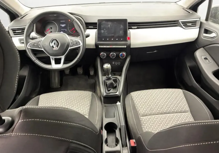 Vue intérieure avant de la Renault Clio V TCe 100 GPL Evolution 2023, tableau de bord noir et sièges tissu gris à motifs.