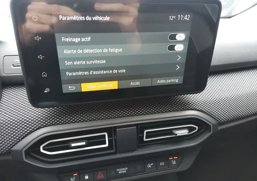 Écran tactile du tableau de bord de la Dacia Sandero 2025 bleu Iron montrant les paramètres d’aides à la conduite.