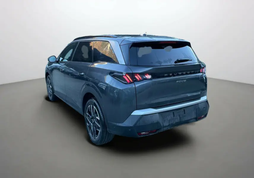 Vue 3/4 arrière droite du Peugeot 5008 Hybrid 145 gris titane avec feux arrière à griffes distinctifs.