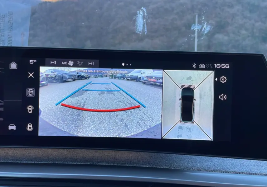 Vue écran caméra de recul et vue aérienne du Peugeot 5008 gris titane hybride 2025 en stationnement.