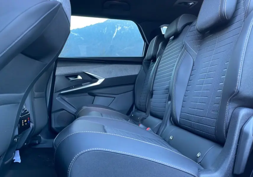 Vue latérale intérieure des sièges arrière en cuir noir avec surpiqûres blanches du Peugeot 5008 Hybrid 145 Allure Plus 2025.