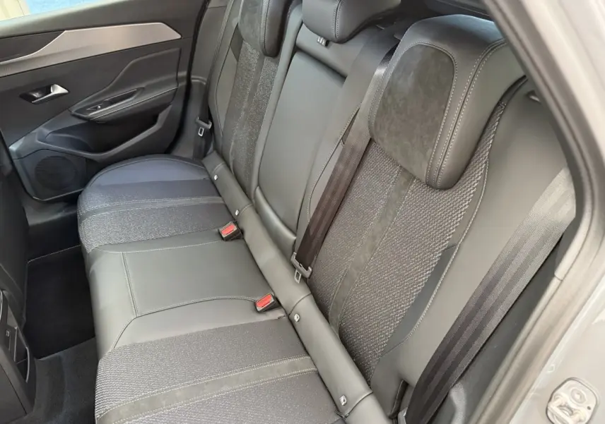 Vue côté droit de la banquette arrière gris foncé en cuir et tissu de la Peugeot 308 Hybrid 136 e-DCS6 GT 2024.