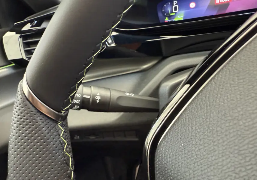 Gros plan sur le volant cuir et le combiné numérique 10 pouces de la Peugeot 308 Hybrid 136 e-DCS6 GT 2024.