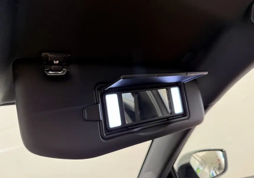 Miroir de courtoisie éclairé sur pare-soleil côté conducteur dans Peugeot 308 Hybrid gris foncé, vue intérieure rapprochée.