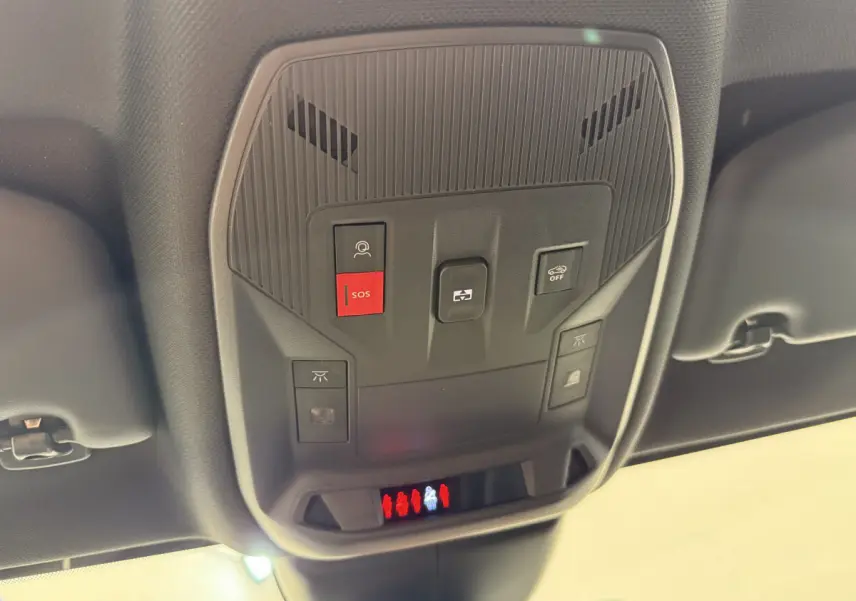 Vue en contre-plongée du panneau de commandes au plafond intérieur de la Peugeot 308 Hybrid gris foncé, avec bouton SOS rouge visible.