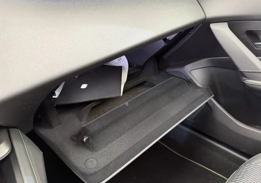 Gant de boîte à gants ouvert côté passager dans l'habitacle gris foncé d'une Peugeot 308 Hybrid 2024.