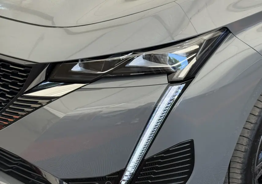 Gros plan sur le phare avant droit LED du Peugeot 308 Hybrid 136 e-DCS6 GT gris foncé 2024.