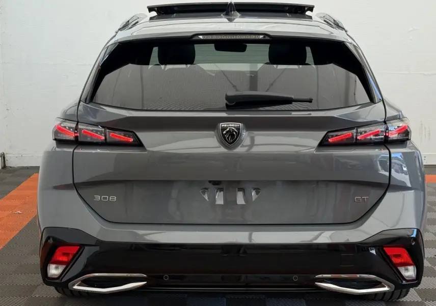 Vue arrière d'une Peugeot 308 GT gris foncé avec feux LED et double sortie d'échappement chromée.
