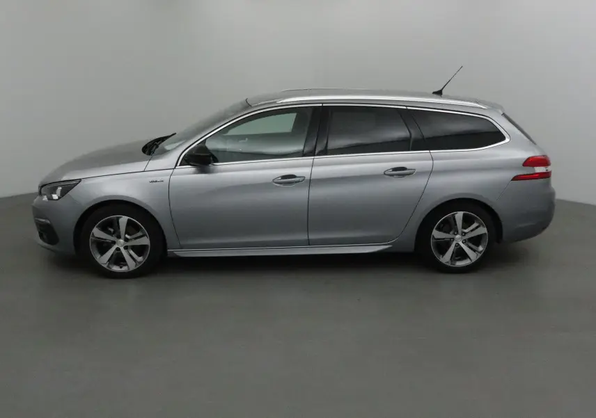 Profil droit d'une Peugeot 308 SW 1.5 BlueHDi 130 GT Line gris Artense avec jantes alliage et vitres teintées.