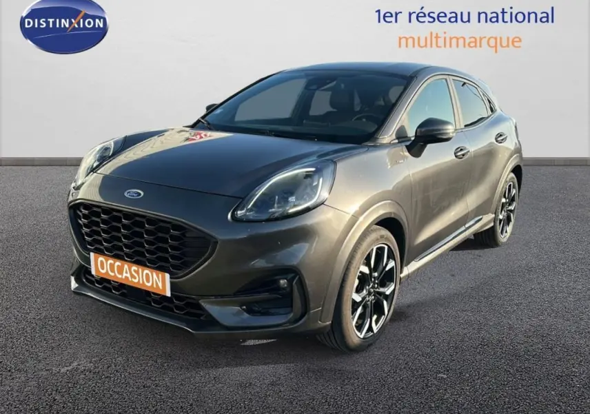 Vue 3/4 avant d'une Ford Puma gris foncé avec jantes alliage noires et vitres surteintées sur fond neutre.