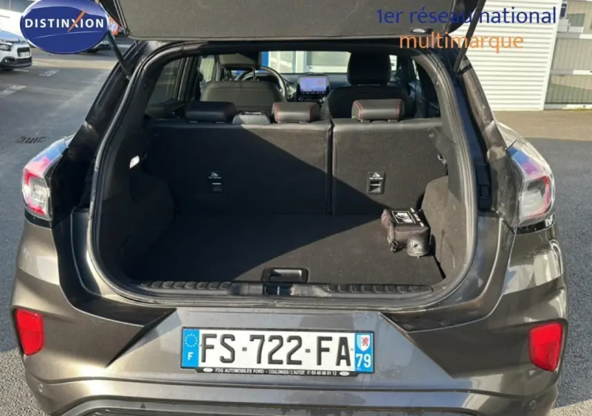 Vue arrière ouverte du Ford Puma gris foncé 2020, montrant le coffre spacieux et les feux arrière.