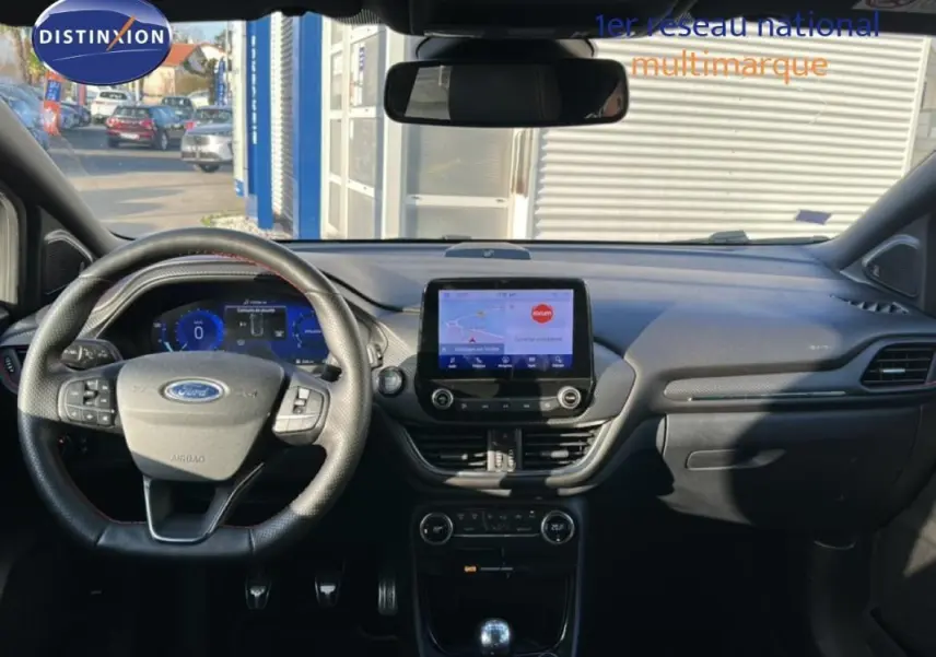 Vue intérieure avant du Ford Puma 2020, tableau de bord noir avec écran tactile et volant multifonction.