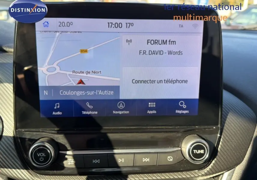 Écran tactile central du Ford Puma 2020 affichant la navigation et la radio, avec commandes audio en bas.
