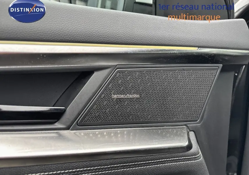 Gros plan sur la porte côté droit du Renault Austral noir étoile métal, mettant en valeur l'enceinte Harman Kardon intégrée.