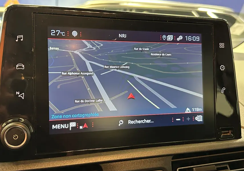 Écran GPS en gros plan dans le tableau de bord du Peugeot Rifter 2019, affichant une carte routière détaillée.