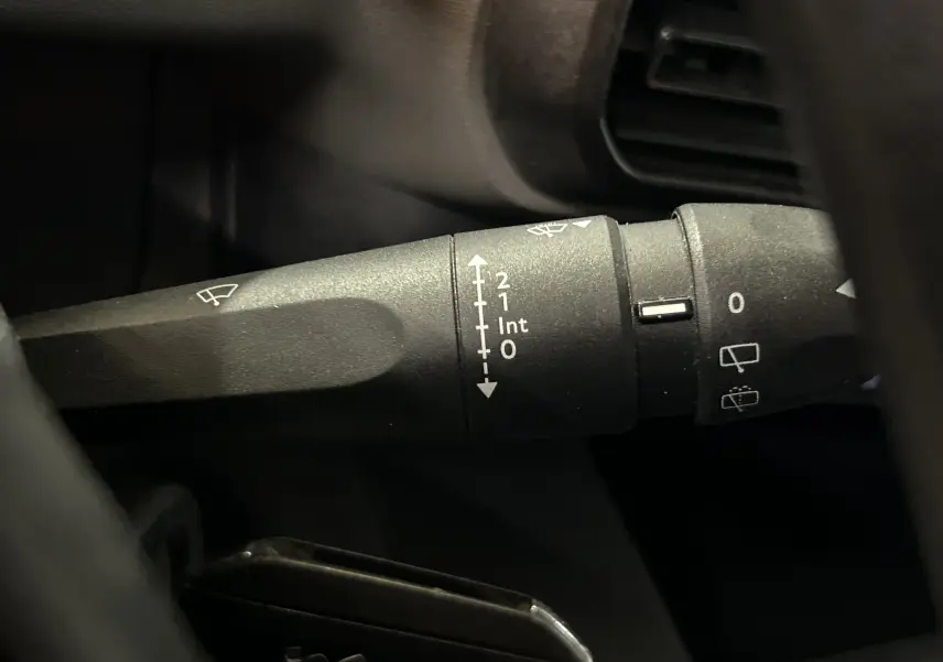 Gros plan sur la manette d'essuie-glace du Peugeot Rifter gris sable, côté gauche du volant, intérieur 2019.
