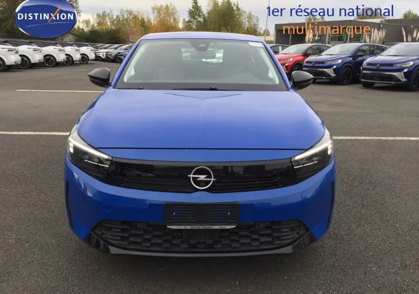 Opel Corsa 2025 bleu voltaik metal vue de face, avec calandre noire et phares LED allumés.