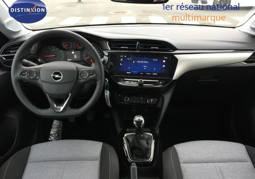 Vue intérieure avant de l'Opel Corsa 2025 avec tableau de bord moderne, volant multifonction et levier de vitesse manuel.