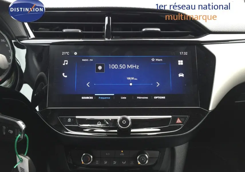 Tableau de bord de l'Opel Corsa 2025 avec écran tactile central affichant la radio FM, ambiance intérieure noire.