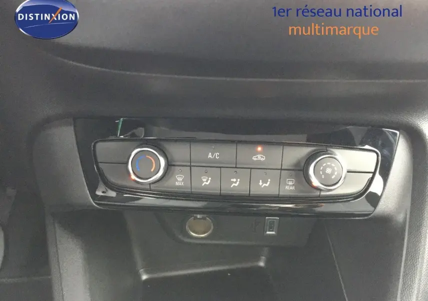 Panneau de commande de climatisation de l'Opel Corsa 2025 en gros plan, avec réglages manuels et finition noire brillante.