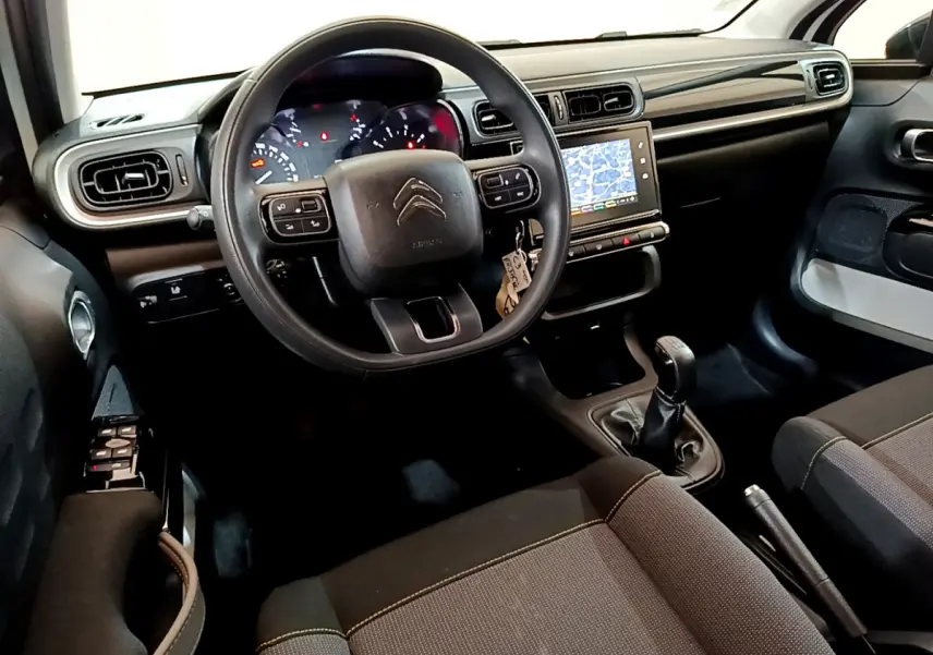 Intérieur de la Citroën C3 2019 vu côté conducteur, volant multifonctions, écran tactile 7 pouces et boîte manuelle noire.