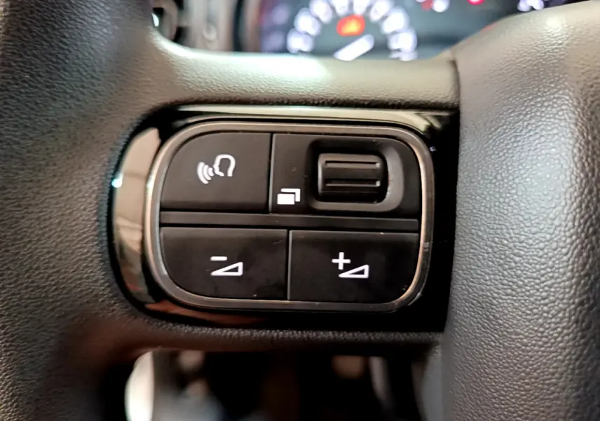 Gros plan sur les commandes vocales et volume au volant de la Citroën C3 blanche, version Feel Business 2019.