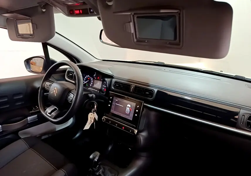 Vue intérieure côté conducteur de la Citroën C3 blanche 2019 avec tableau de bord noir et écran tactile central.