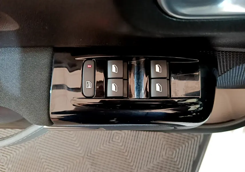 Gros plan sur les commandes de lève-vitres électriques côté conducteur d'une Citroën C3 blanche de 2019.