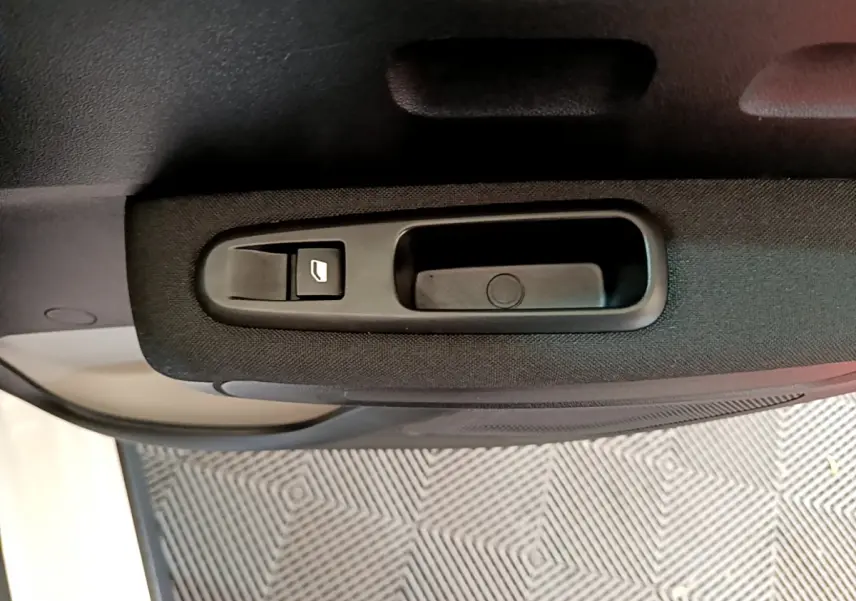 Gros plan sur la commande de lève-vitre côté gauche de la porte intérieure d'une Citroën C3 blanche 2019.