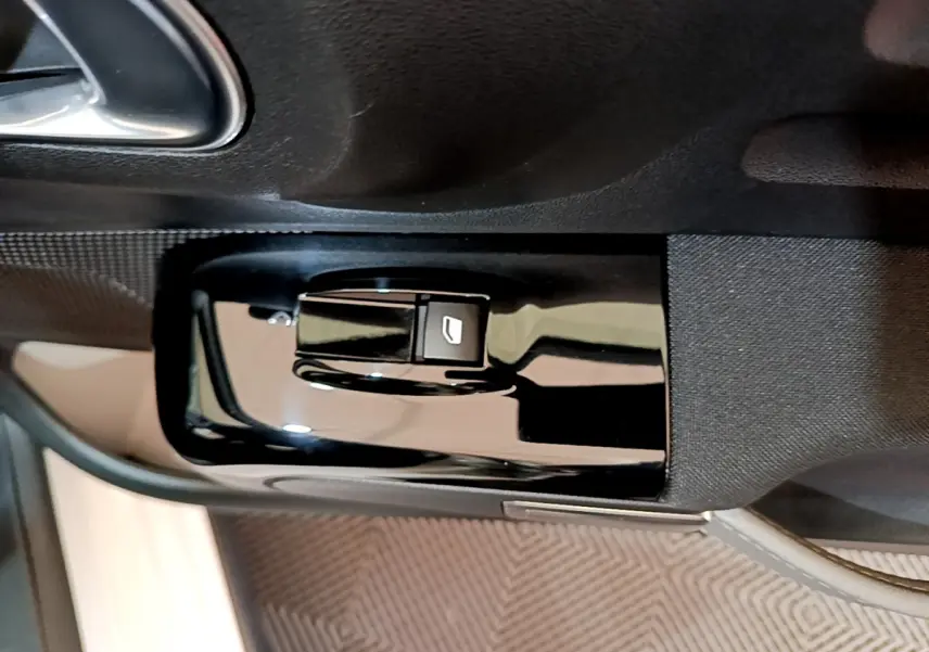 Gros plan sur la commande de lève-vitre côté conducteur de la Citroën C3 blanche, finition Feel Business.