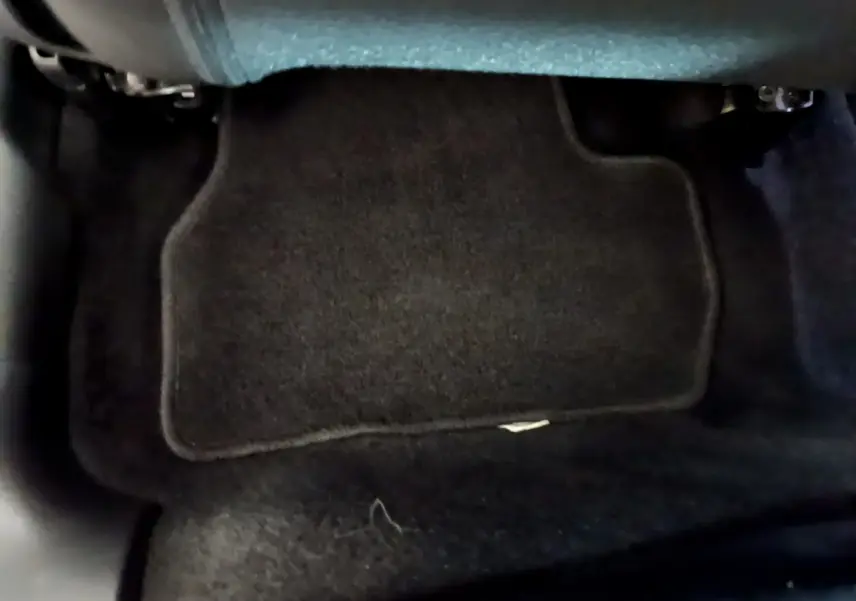Vue rapprochée du tapis de sol noir côté conducteur dans une Citroën C3 blanche de 2019.