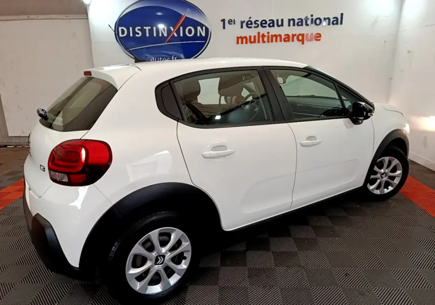 Citroën C3 blanc vue de côté droit arrière, avec jantes alliage et protections noires sur les passages de roues.