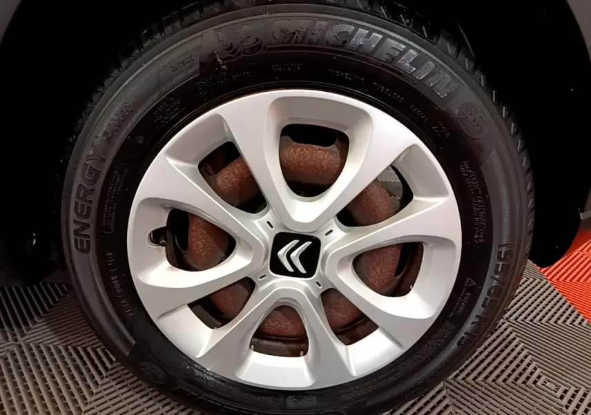 Gros plan sur la roue avant droite d'une Citroën C3 blanche, avec jante en alliage et pneu Michelin Energy.