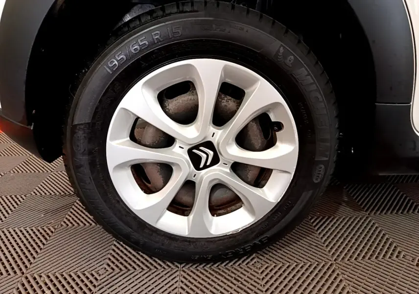 Gros plan sur la roue avant droite d'une Citroën C3 blanche de 2019 avec jante alliage et pneu Michelin.