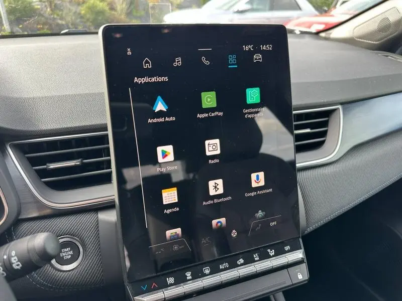 Vue rapprochée de l’écran tactile central du Renault Captur 2026, affichant les applications connectées, avec tableau de bord gris et détails noirs.
