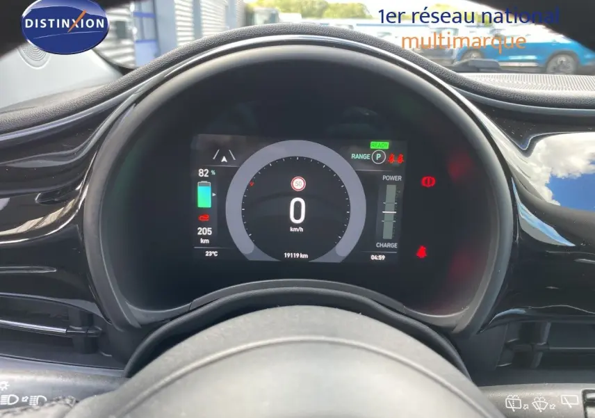 Vue rapprochée du tableau de bord numérique de la Fiat 500 électrique noire 2023, affichant la vitesse et l'autonomie.