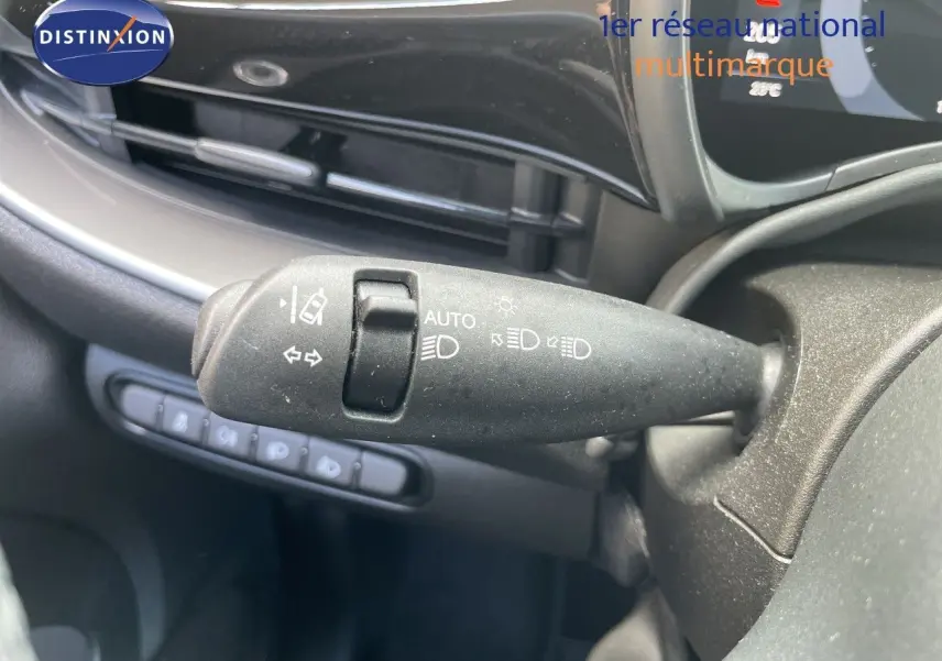 Gros plan sur la commande des feux et clignotants côté gauche du tableau de bord d'une Fiat 500 électrique noire 2023.
