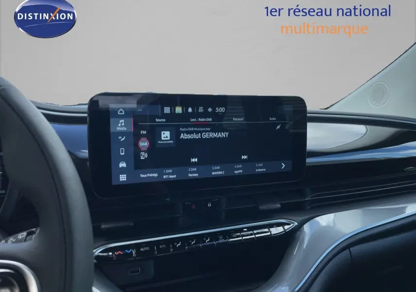 Vue intérieure du tableau de bord de la Fiat 500 électrique 2023, avec écran tactile central affichant une radio numérique.