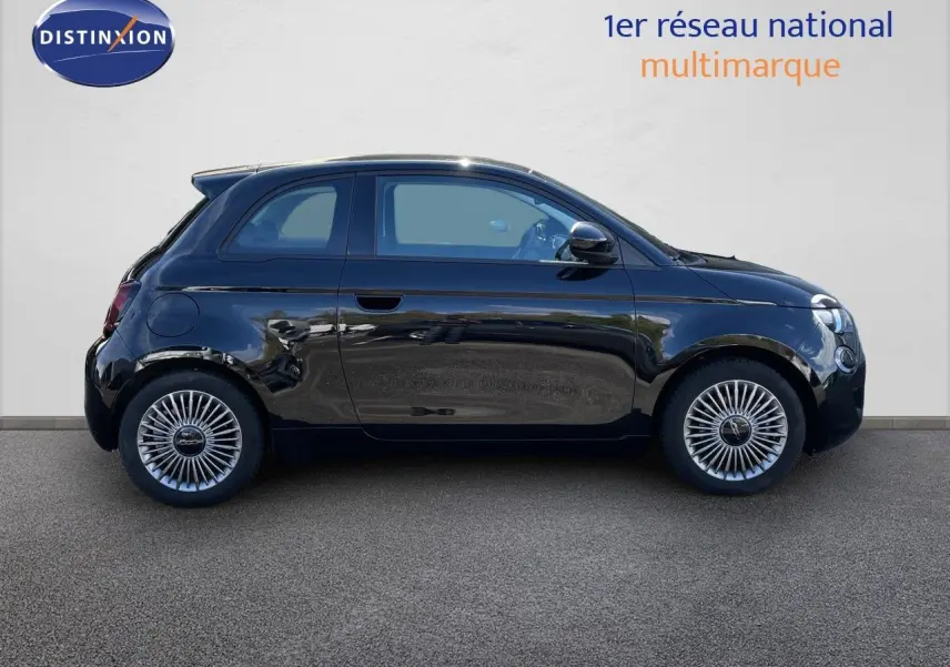 Profil côté gauche de la Fiat 500 électrique noire 2023 avec jantes spécifiques et lignes compactes urbaines.