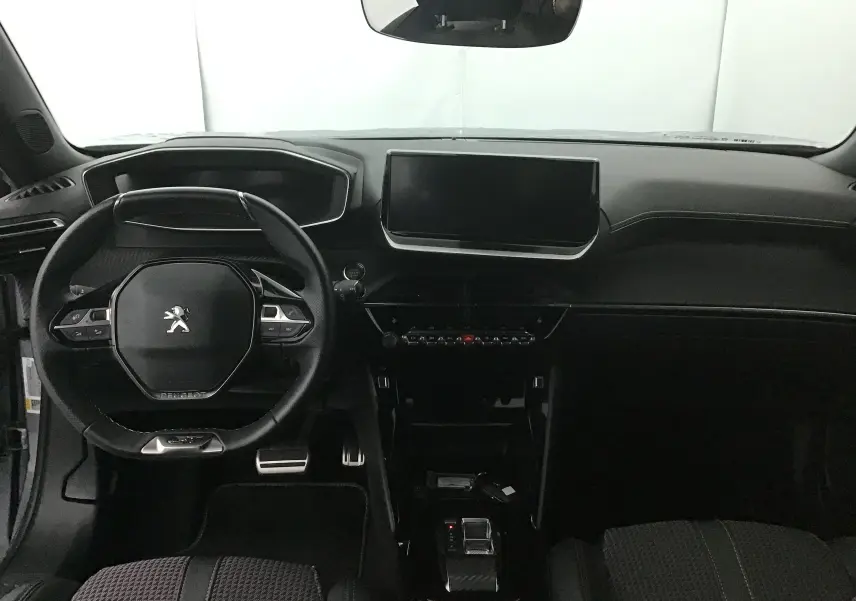 Vue intérieure frontale du tableau de bord et volant du Peugeot 2008 électrique gris Artense/Noir, avec écran tactile central et finitions modernes.