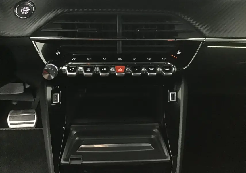 Tableau de bord noir de la Peugeot 2008 électrique 2022, avec commandes tactiles et bouton start/stop visible.