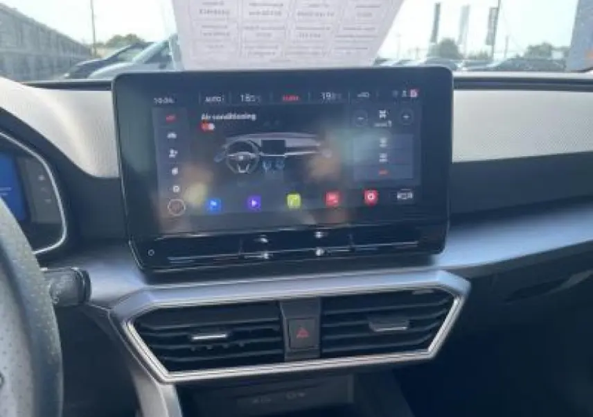 Vue intérieure centrée sur l'écran tactile 10 pouces du tableau de bord du SEAT Leon blanc Nevada 2024.