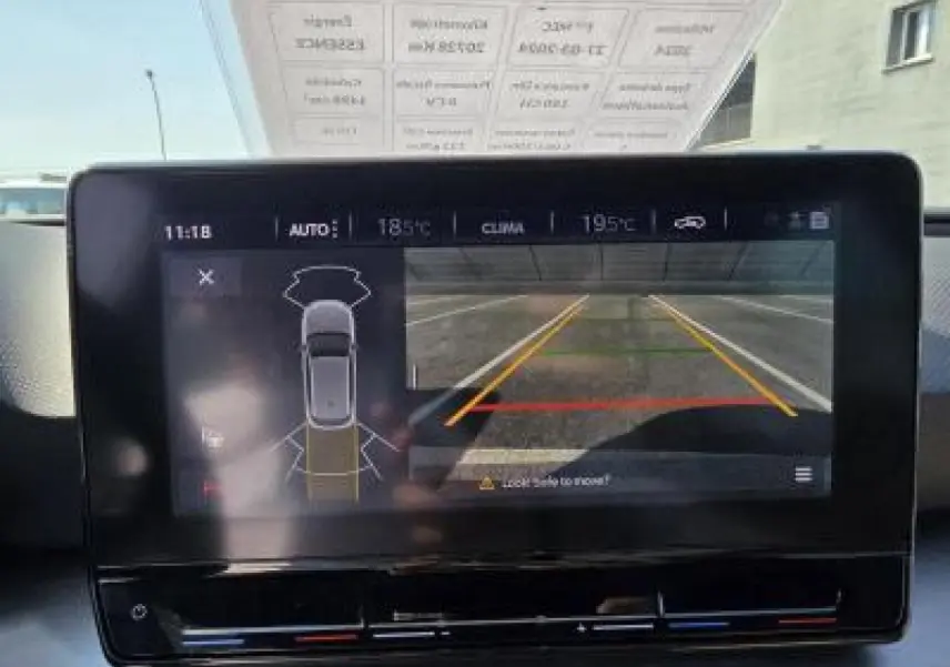 Écran tactile central montrant la caméra de recul et l'aide au stationnement d'une SEAT Leon blanc Nevada, vue intérieure avant.