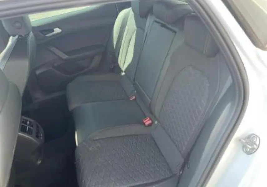 Vue intérieure côté droit sur la banquette arrière noire avec surpiqûres rouges d'une SEAT LEON IV Blanc Nevada 2024.