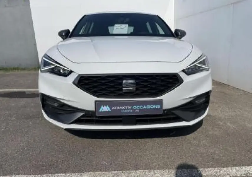 Vue frontale d'une SEAT Leon IV blanche Nevada avec calandre noire et phares LED anguleux.