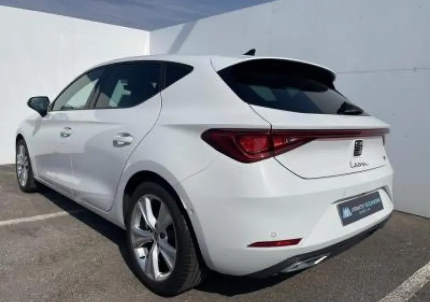 SEAT Leon blanc Nevada vue 3/4 arrière droit, jantes alliage 17 pouces et vitres arrière surteintées.