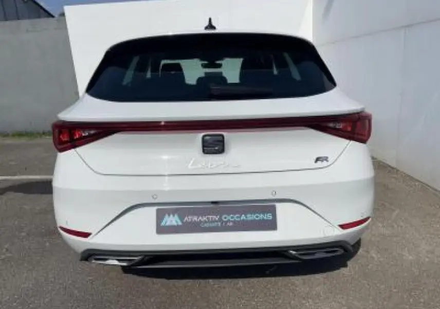Vue arrière d'une SEAT Leon IV blanche Nevada avec logo FR et feux arrière reliés par une bande lumineuse rouge.